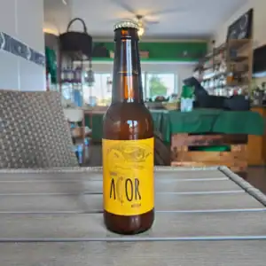 Cerveja artesanal com rótulo amarelo e ilustração de um pássaro, ideal para amantes de bebidas especiais.