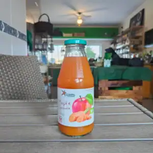 Suco natural de maçã e cenoura biodinâmico em garrafa de vidro.